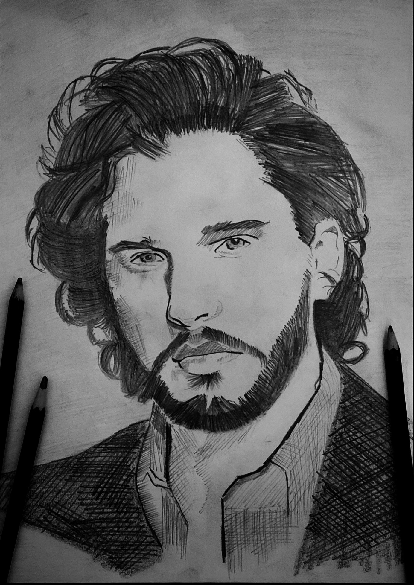 A pencil portrait sketch of a bearded man with curly hair.