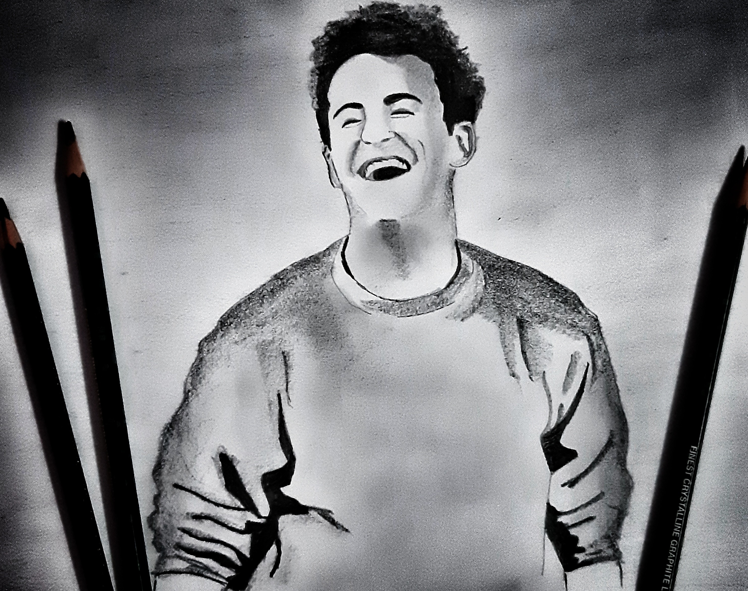 A charcoal portrait sketch of a laughing man.
